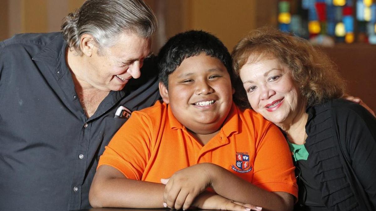 Nelson Sobrino Jr. junto a sus padres adoptivos, Nelson Sobrino Sr. y Zoila Sobrino. El niño es el nuevo presidente del cuerpo estudiantil en el Somerset City Arts Conservatory, en Homestead.