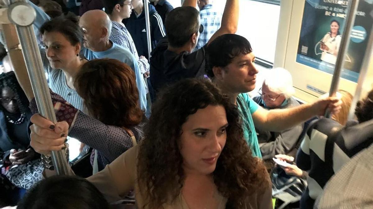 Denise Pérez viaja en uno de los trenes del Metrorail, durante la hora pico de la tarde. Los vagones atiborrados de gente y largas espera por los trenes son comunes para usuarios como Pérez.