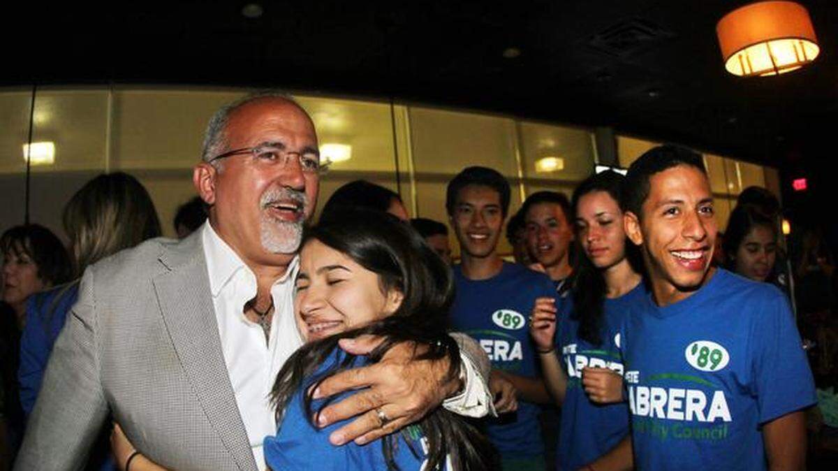 Estudiante de la escuela Ronald Reagan, abraza al candidato Peter Cabrera al saber de su triunfo contra Bettina Rodríguez-Aguilera para el puesto de concejal de la ciudad de Doral, en el restaurante Braseros en la ciudad del Doral el martes, 4 de noviembre del 2014.
