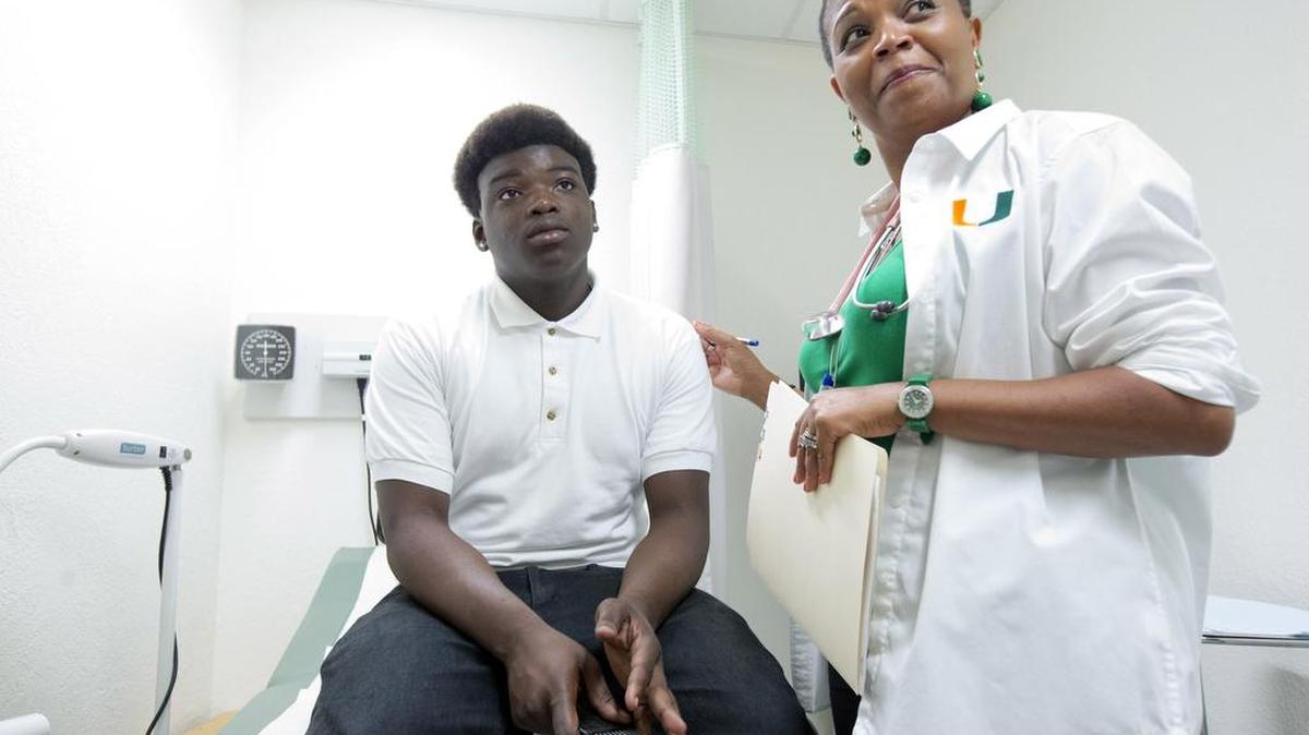 El joven Amos LeClerc es examinado por la Dra. Marie-Denise Gervais en la enfermería en el Miami High School, en el 2014.