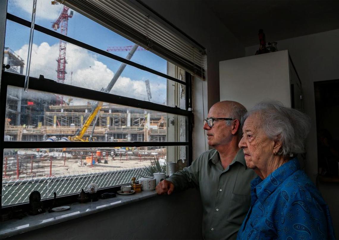 The construction of Plaza at Coral Gables is seen through the dining room window at the home of Orlando Capote, 63, and his mother, Lucia Capote, 90, in this 2019 Herald file photo. The family refused to sell to developers.