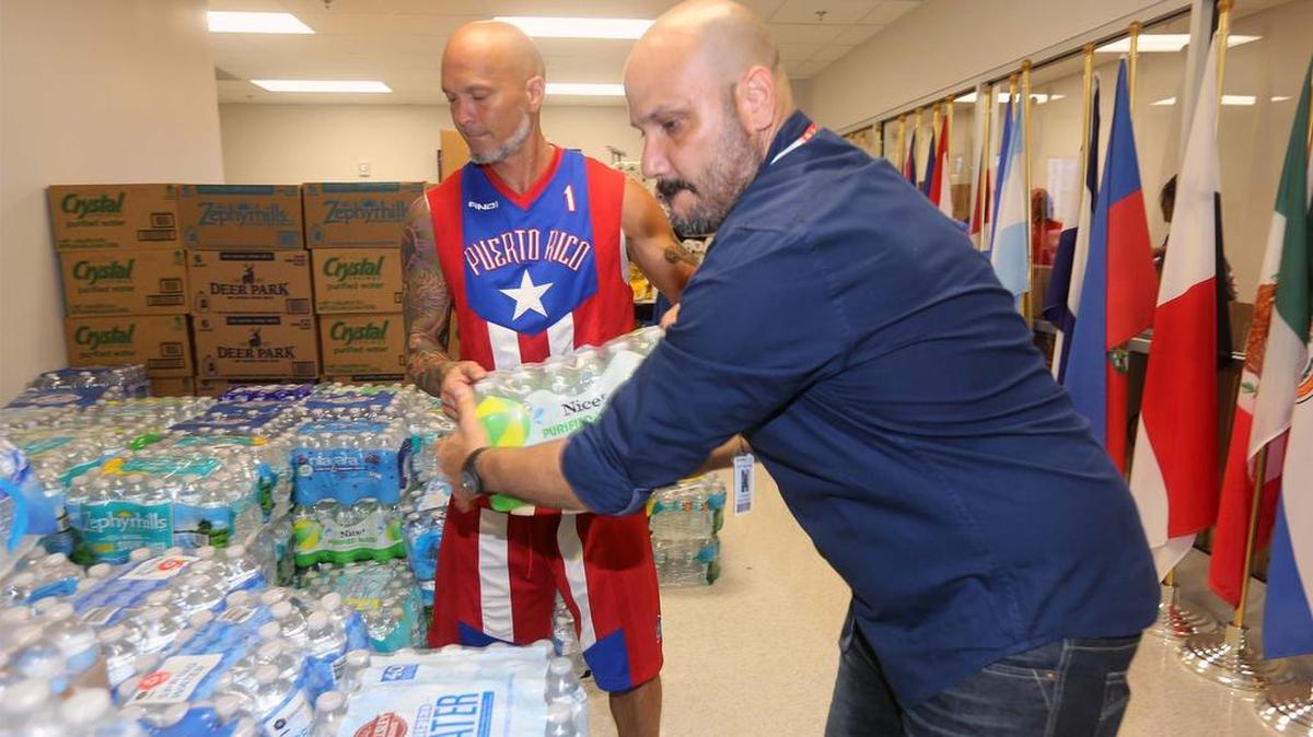Víctor Méndez (der.) y Billy Riaño ayudan a recolectar donaciones de artículos de primera necesidad para enviar a Puerto Rico, el sábado en la sede del Sistema Universitario Ana G. Méndez (SUAGM) (Campus del Sur de la Florida) en Miami Lakes.