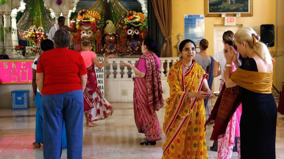 Varshana Citra (centro) distribuye el “prasadam” a los devotos que participan del festín dominical en el templo Hare Krishna de Coconut Grove.