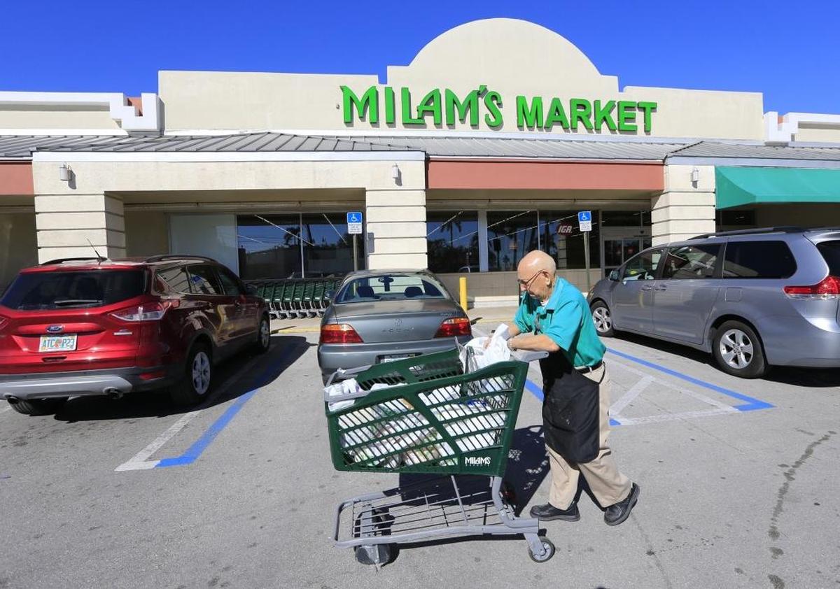Antonio Guasp, siempre sonriente y profesional, ayuda a los clientes a llevar los carros de mercancía hasta el auto, en el supermercado Milam de Miami Springs, el 15 de diciembre.