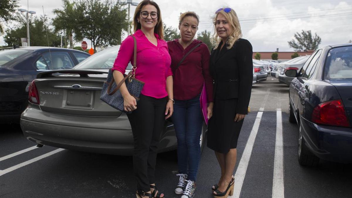 De izq. a der. la directora de Life of Hope, Ivón Linares; la nicaragüense Mónica González y la abogada Elena Ortega, posan frente al auto donado el jueves por Doral Lincoln.