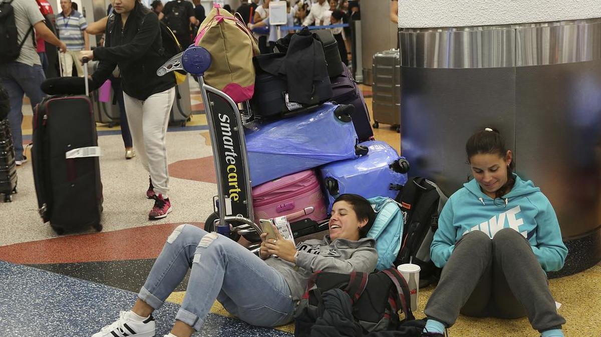 Yanina Fernandez (izq.) y su hermana Liz esperan para tomar un vuelo a Argentina después que su previo vuelo fuera cancelado, el jueves en el Aeropuerto Internacional de Miami.
