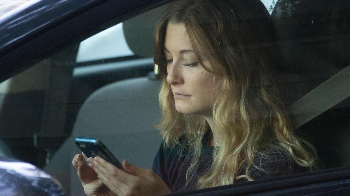 Una mujer usa su celular mientras espera salir de un trancón en Sacramento el 22 de junio del 2016.