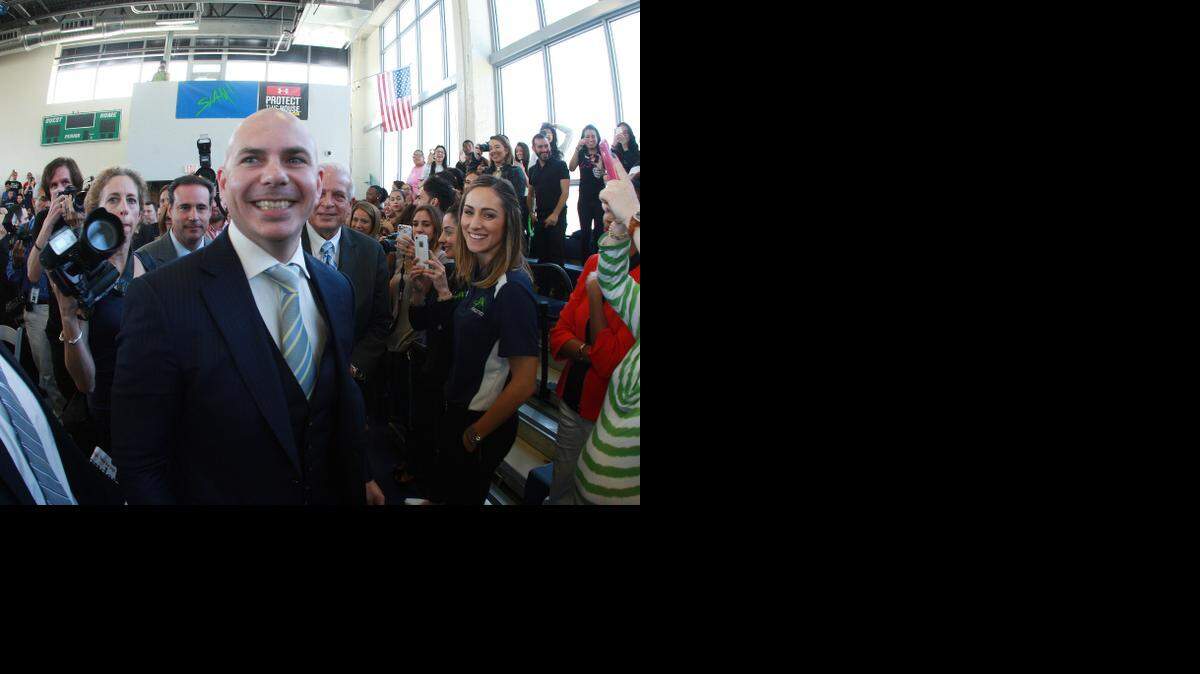 
Armando Christian Perez 'Pitbull' (centro) sonrie durante el evento que se realizara en la escuela Slam Chapter School en la Pequeña Habana el jueves, 15 de enero del 2015. 
