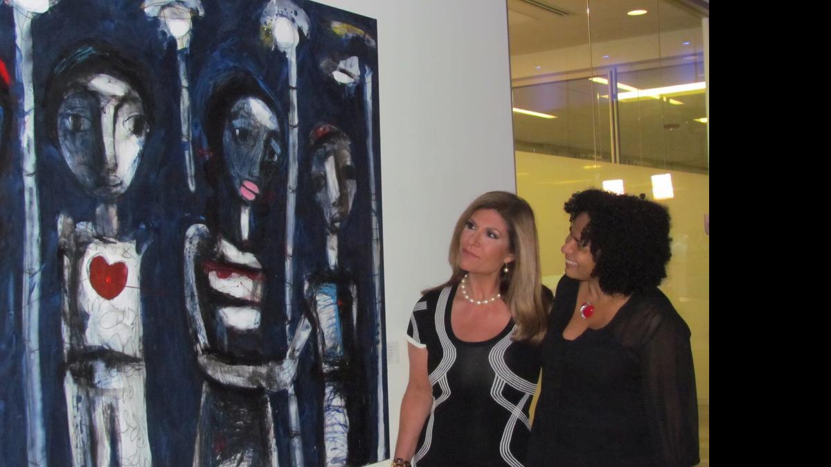 
La artista Iris Pérez Romero con la presentadora de Univisión Teresa Rodríguez en la inauguración de la muestra en el edificio Newsport de Univisión/Noticias.
