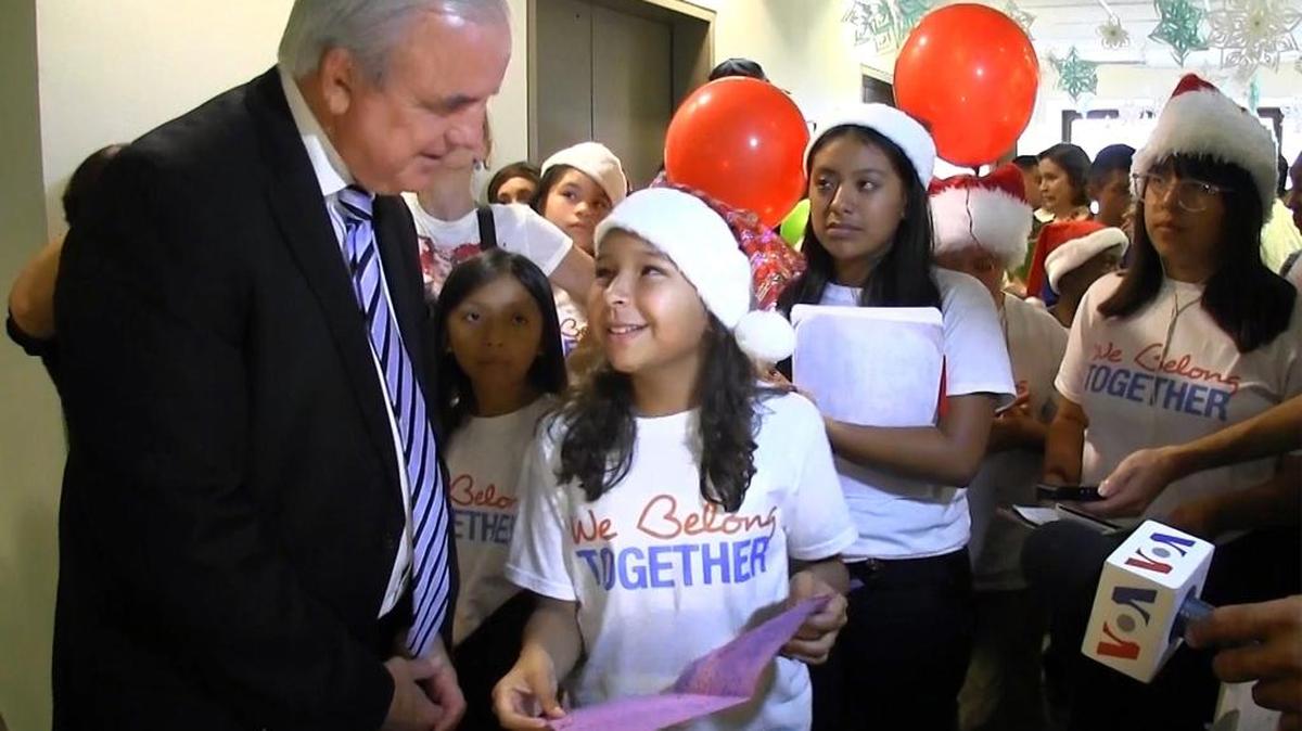 El alcalde de Miami-Dade Carlos Giménez escucha a Leah Cayasso, de 11 años, que lee una carta pidiendo protección contra la deportación de sus padres, que son indocumentados. Foto de archivo.