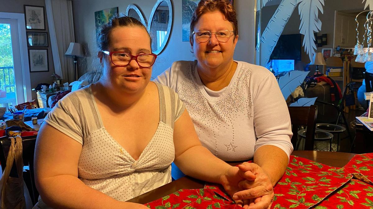 Taylor Quinones (izquierda) y su madre, Tonya Morrison, en la cocina de su apartamento de Pompano Beach. Para Quinones, que tiene síndrome de Down, nadar con delfines podría ser terapéutico y proporcionar algo de alegría.