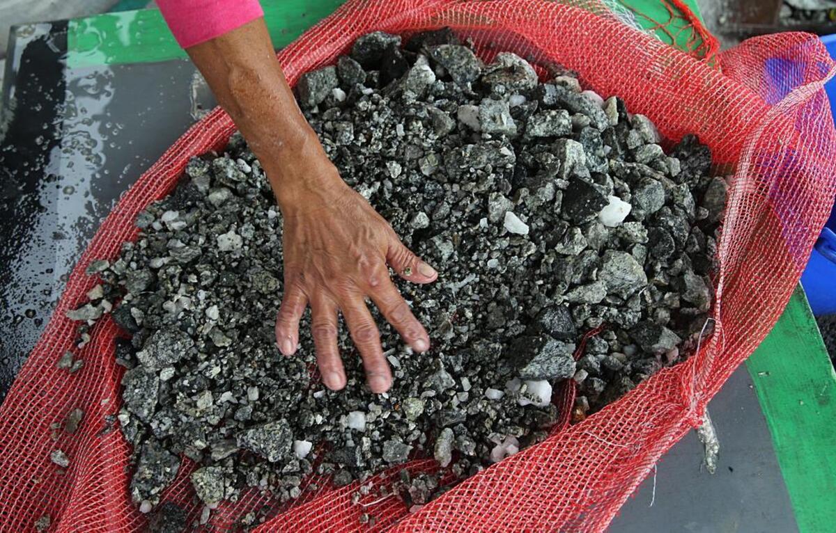 Doris Fonegra, una de un grupo de trabajadores, en su mayoría mujeres llamadas chatarreras, busca partículas de oro en un montón de piedras extraídas de la mina de oro independiente Las Brisas, en el poblado de Segovia, departamento de Antioquia, Colombia.
