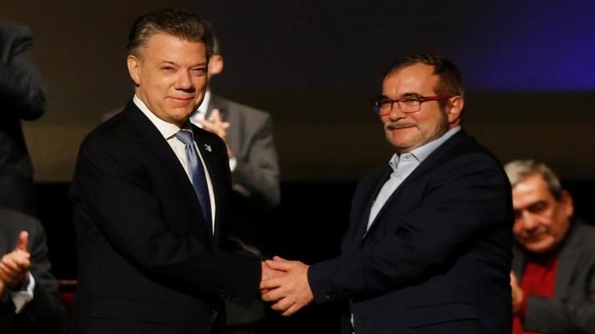 El presidente de Colombia, Juan Manuel Santos (izq.), saluda el jueves a Rodrigo Londoño, alias Timochenko, el líder de la guerrilla de las FARC, en Bogotá.