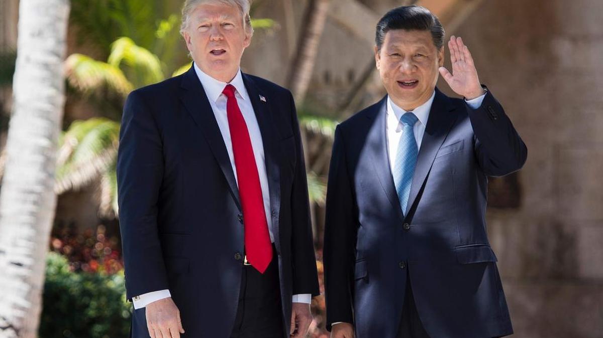 El presidente chino Xi Jinping (R) saluda a la prensa mientras camina con el presidente estadounidense, Donald Trump, en la finca Mar-a-Lago en West Palm Beach, Florida, el 7 de abril de 2017.