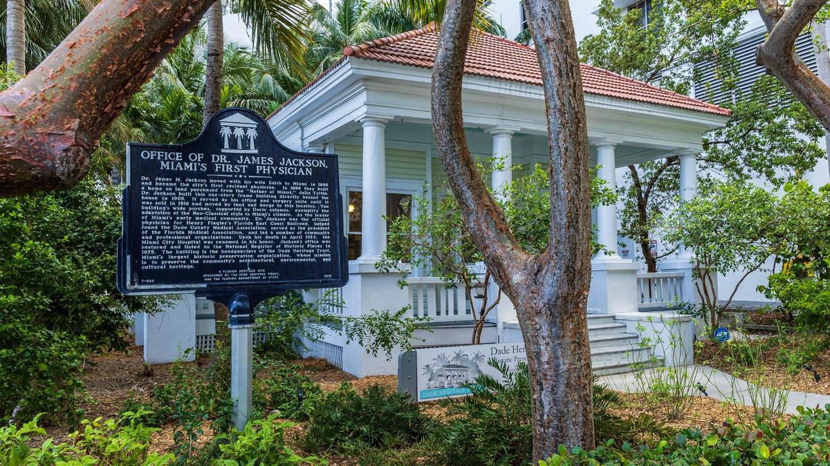 La casita de madera, que parece un sándwich entre los altos edificios de Brickell, tiene una larga historia como la oficina del primer médico de Miami, el Dr. James M. Jackson. El podcast de Miami Oculto te invita a recorrerla y a aprender sobre la sede actual de Dade Heritage Trust, en el 190 SE 12 Terrace.