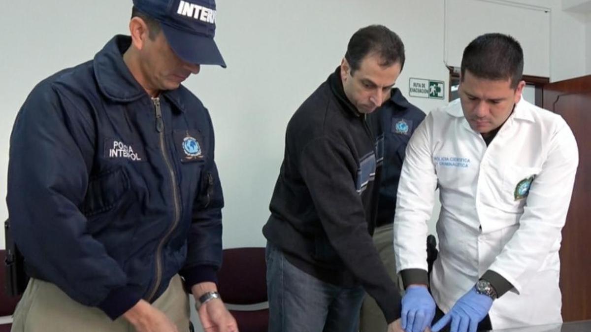 Un agente le toma las huellas al empresario Nidal Waked Hatum (cen.) el jueves en Bogotá antes de ser extraditado a EEUU.