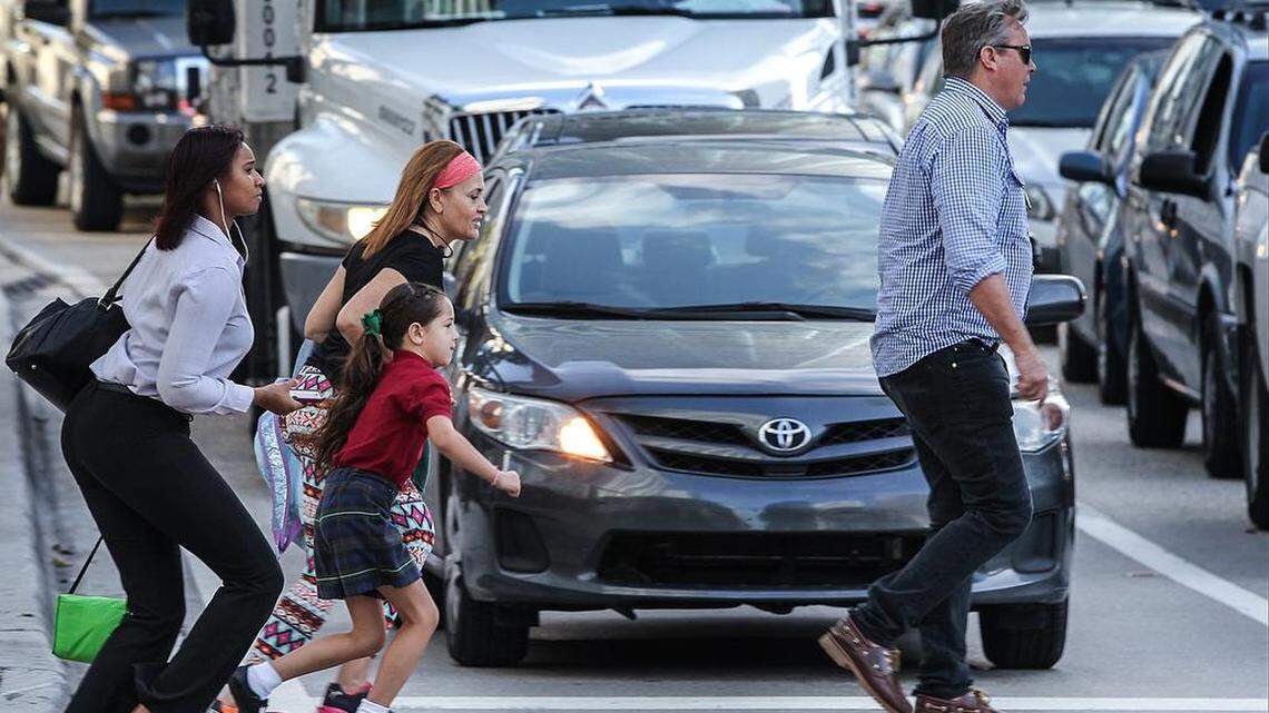 Peatones se apuran al cruzar el puente de la avenida Brickell en mayo de 2015.