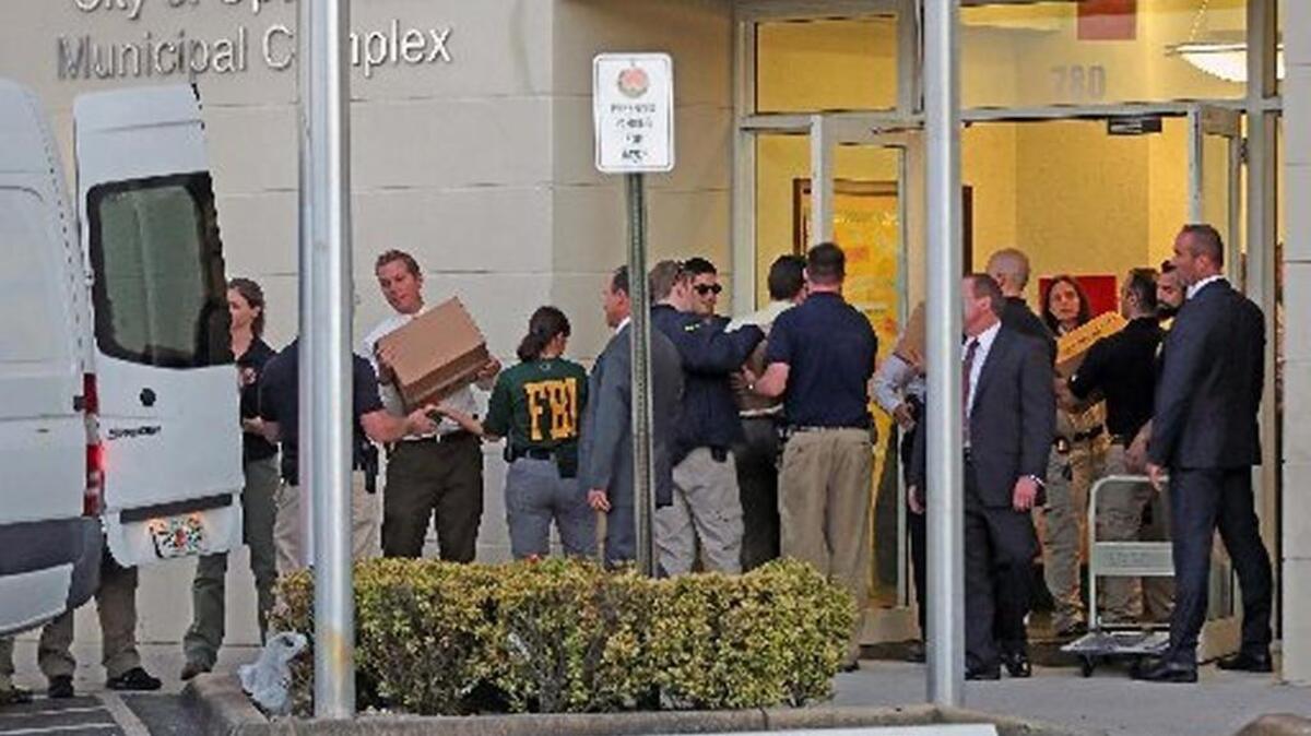 Agentes del FBI remueven cajas de documentos como evidencia del edificio sede del gobierno de la ciudad de Opa-Locka, en marzo. elnuevoherald.com