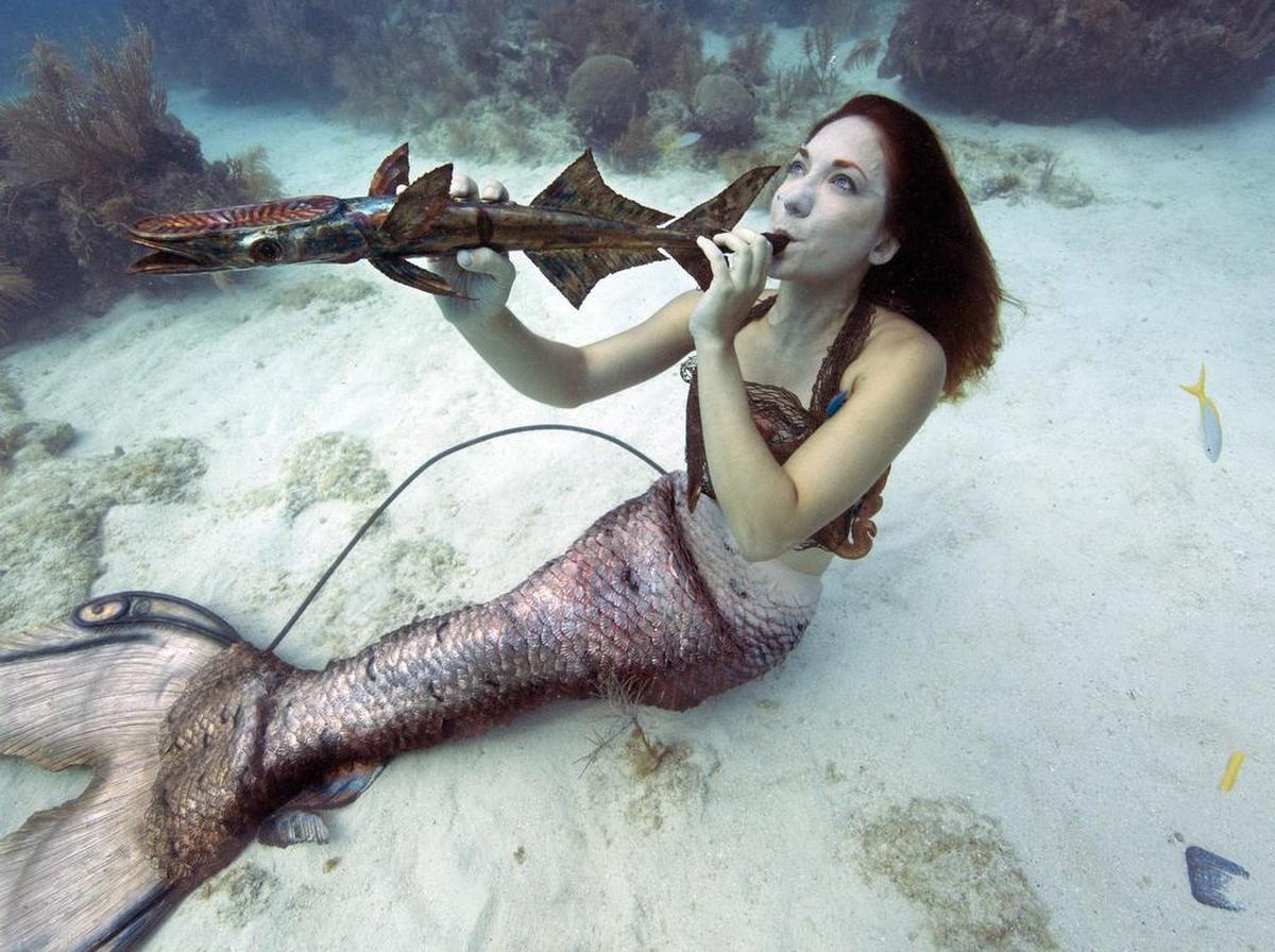 Mariah Reynolds, vestida como una sirena, finge tocar un instrumento musical el sábado 8 de julio de 2017, en el Underwater Music Festival en el Santuario Marino Nacional de Florida Keys de Big Pine Key, Florida.