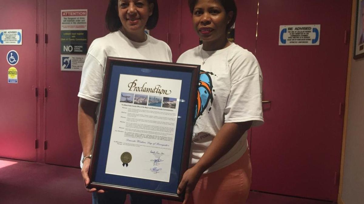 Milagros Jiménez y Carla Hansack, miembros de la Coalición de Trabajadoras del Hogar de Miami-Dade, posan el martes con la proclama que reconoce a su industria, en el Centro de Gobierno condal.