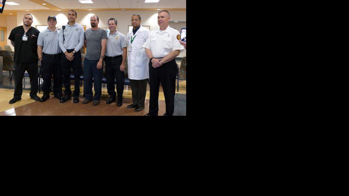 
Anthony Toledo, centro, y el Dr. Mark Cockburn (segundo desde la izquierda) junto a varios rescatistas y personal del Kendall Regional Medical Center este martes.


