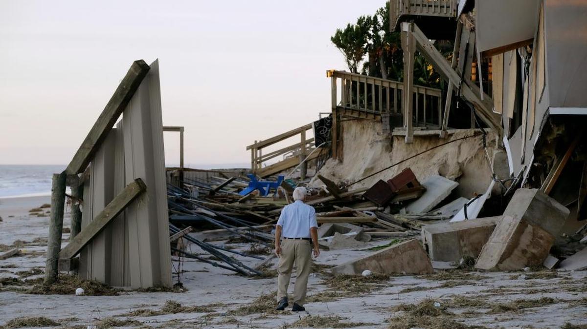 Un hombre observa los daños en una propiedad de su vecindario en Ponte Vedra Beach, Florida, tras el paso de Matthew.