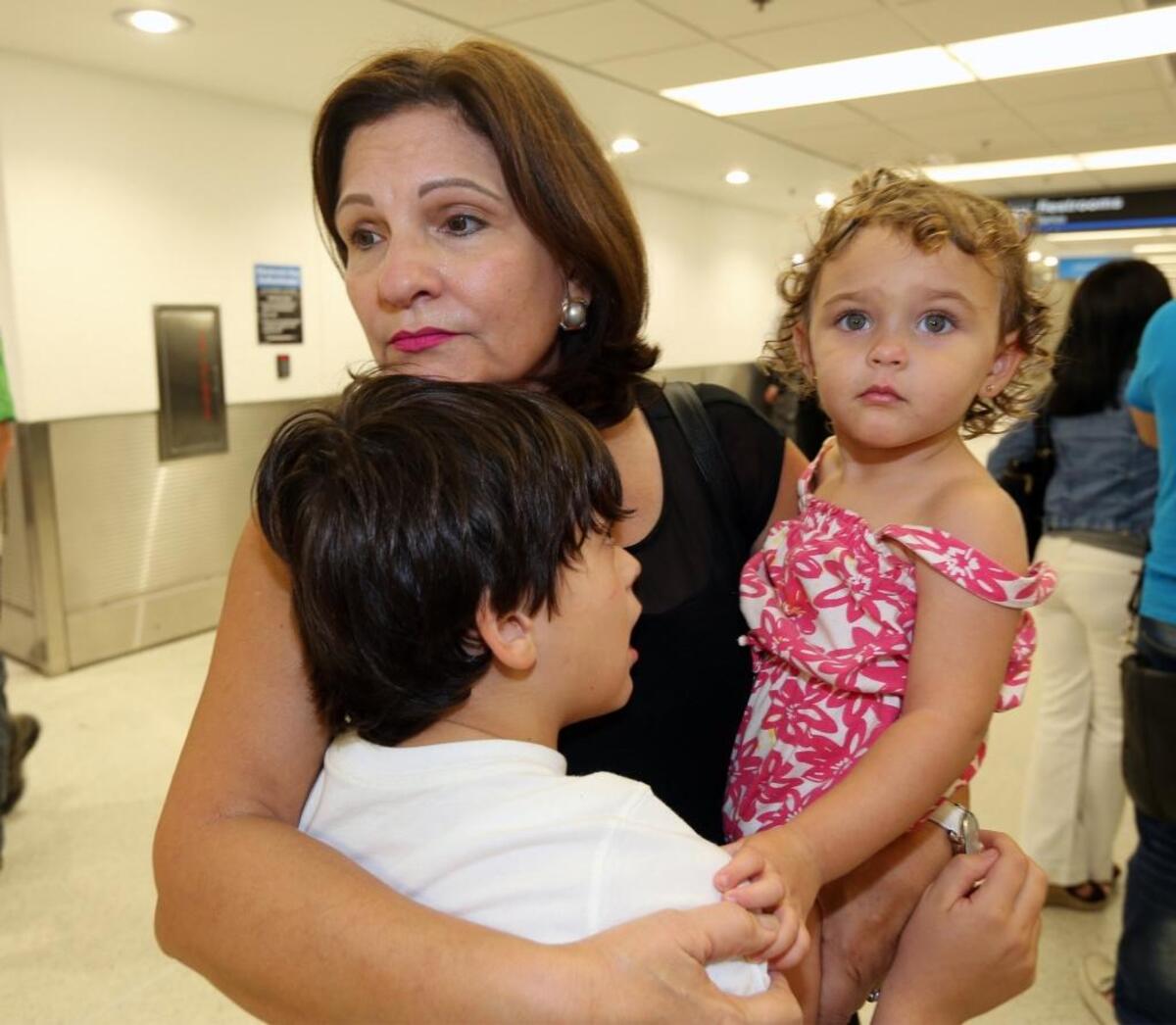 Isabel Padro de Castañer abraza a sus nietos, Lucia Castañer, de 2 años y Alberto Castañer, de 8 años en el Aeropuerto Internacional de Miami. Los niños llegaron desde Puerto Rico el martes.