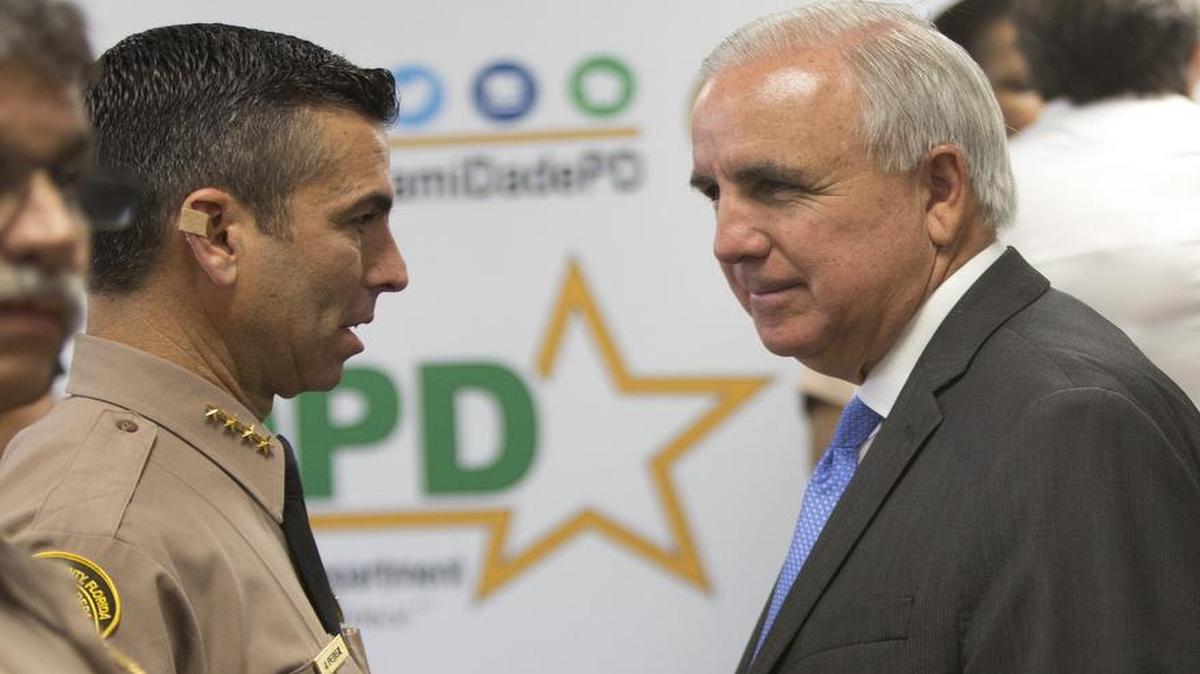 Juan Pérez, jefe de la Policía de Miami-Dade, habla con Carlos Giménez, alcalde condal, después de una conferencia de prensa en abril del 2016.