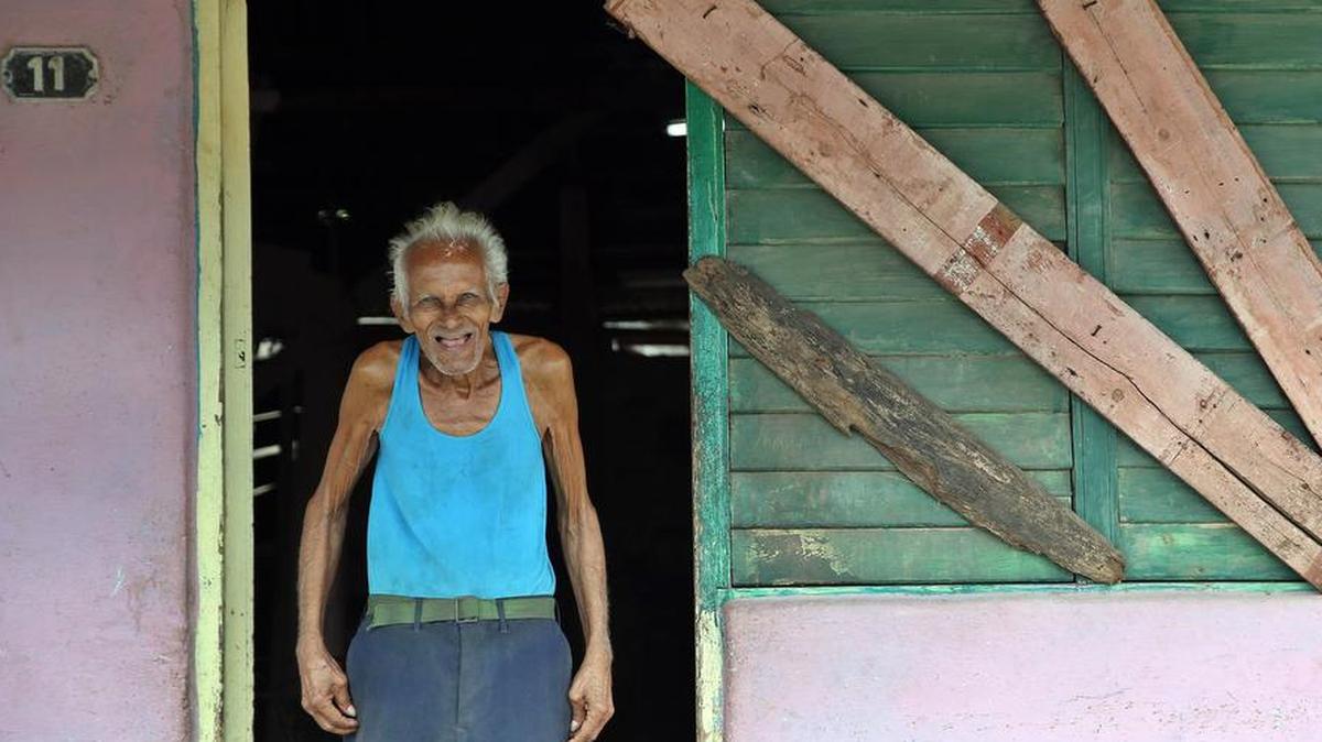 Un anciano posa junto a las ventanas tapiadas de su casa ante la inminente llegada del huracán Irma el viernes 8 de septiembre del 2017, en la localidad de Turiguanó, en la provincia de Ciego de Ávila.