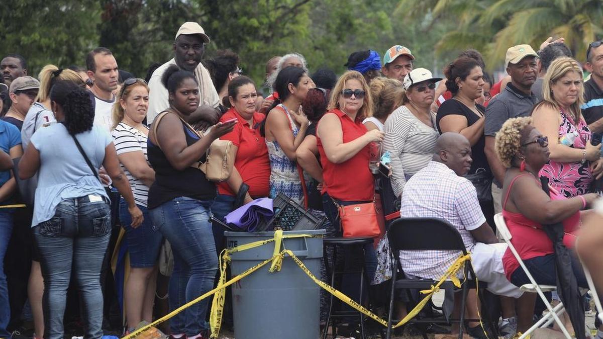 Cientos de personas hacen cola en el centro de asistencia alimentaria de FEMA en Amelia Earhart Park en Hialeah, Florida, el sábado 14 de octubre de 2017.