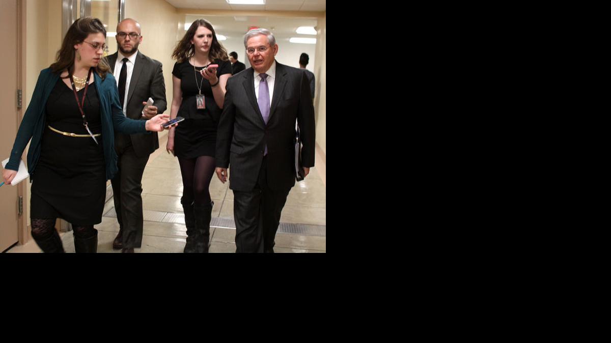 El senador Bob Menéndez, demócrata de Nueva Jersey, a la derecha, es perseguido por los reporteros en el Capitolio en Washington, miércoles, 25 de febrero 2015, mientras los demócratas y los republicanos se dirigen a sus reuniones del caucus del partido para discutir la financiación de la seguridad nacional.