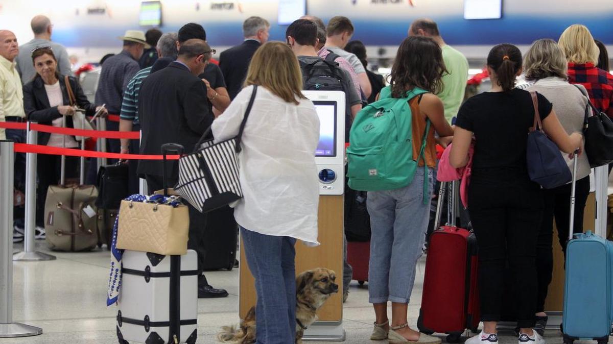 Un grupo de pasajeros espera el miércoles para chequear su equipaje en el Aeropuerto Internacional de Miami.