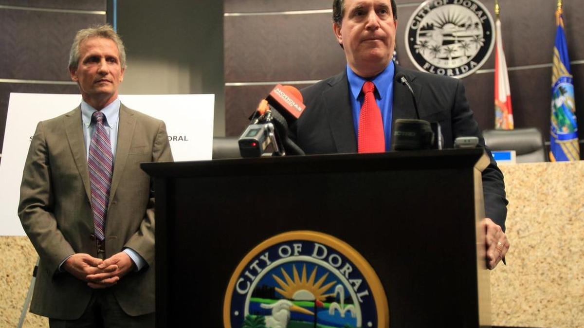 El Administrador de la Ciudad del Doral Joe Carollo habla a los medios de prensa en el 2013, mientras el alcalde Luigi Boria lo escucha.