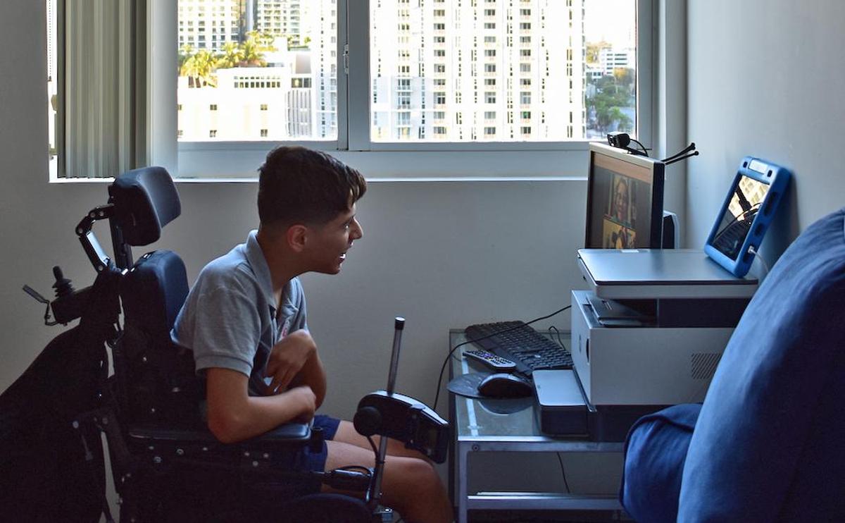 Juan Luna Bustamante, con parálisis cerebral, en su escritorio para sus clases de inglés online.