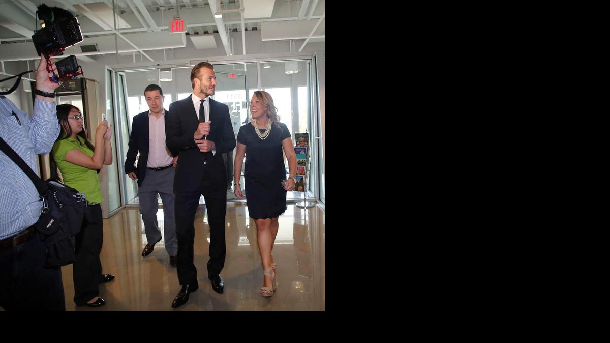 
El ex astro del fútbol inglés David Beckham es recibido, el 8 de mayo del 2014, en el lobby del Miami Herald/el Nuevo Herald por Roxanne Tammone, representante de Relaciones Públicas de la compañía.
