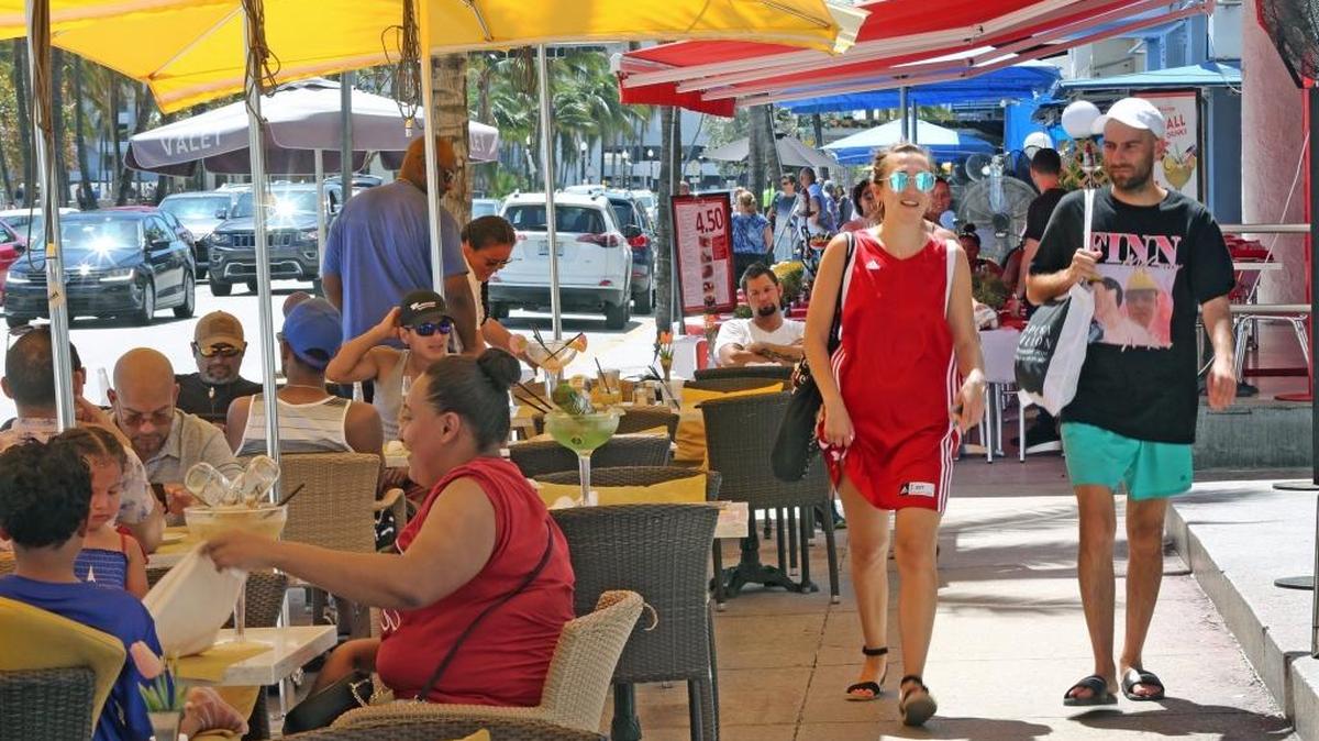 Grupos de turistas disfrutan de una soleada tarde de domingo en Ocean Drive, en Miami Beach.