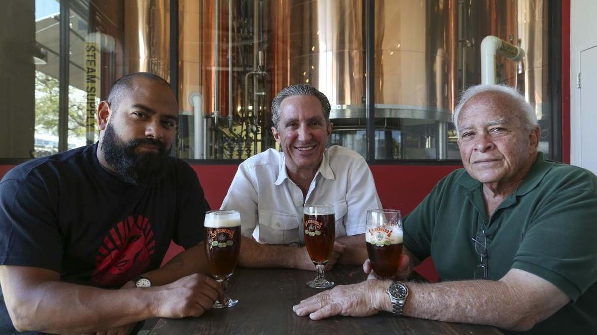 La cervecería Concrete Beach Brewery, de Wynwood, está recreando la cerveza original cubana de 1888, la Tropical, con ayuda de Ramón Blanco Herrera (derecha), de 70 años; Manuel Portuondo (centro), de 49 años, y Marco Reyna, de 30. El tatarabuelo de Portuondo, Federico Kohly, fue una vez dueño de los terrenos de La Habana donde se construyó la Cervecería La Tropical. Portuondo presentó al dueño de Concrete Beach a Ramón Blanco Herrera, cuyo bisabuelo fundó la cervecería.