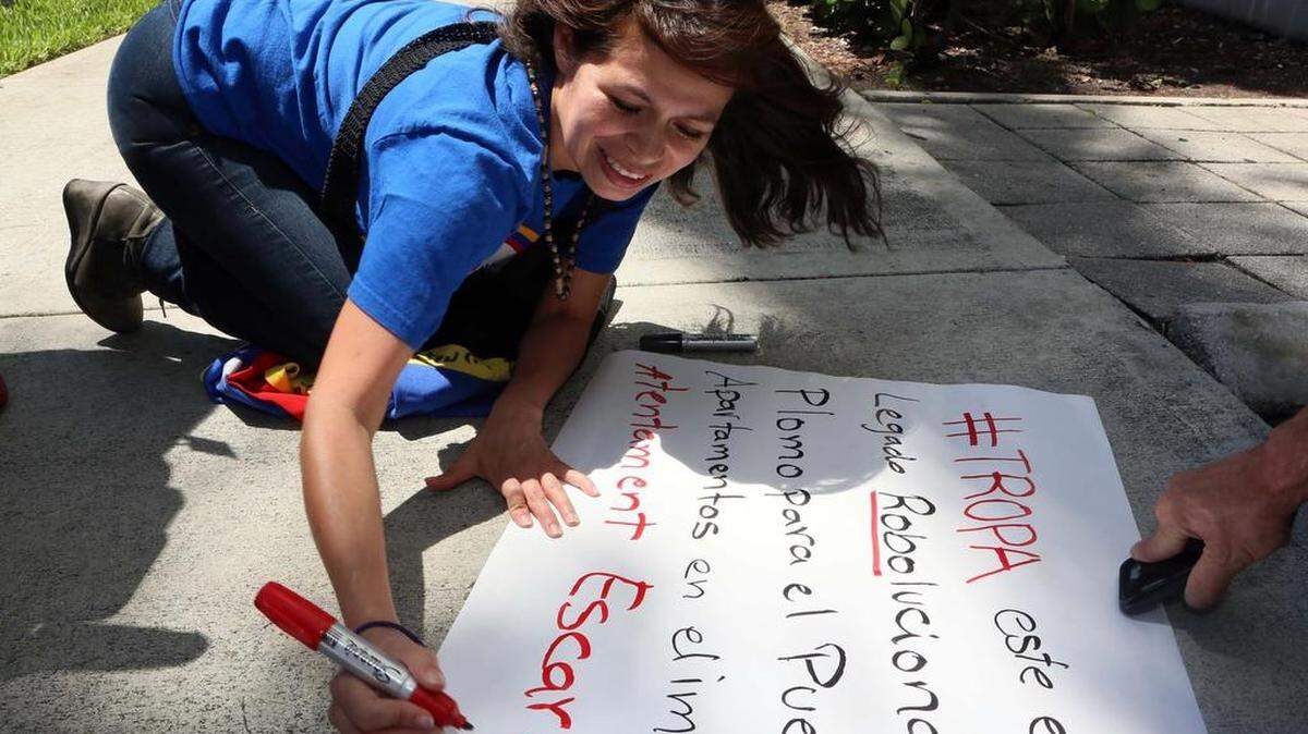 Karyn Salcedo, venezolana exiliada, escribe en un cartel en una de las protestas en Miami el jueves, 26 de mayo de 2016.