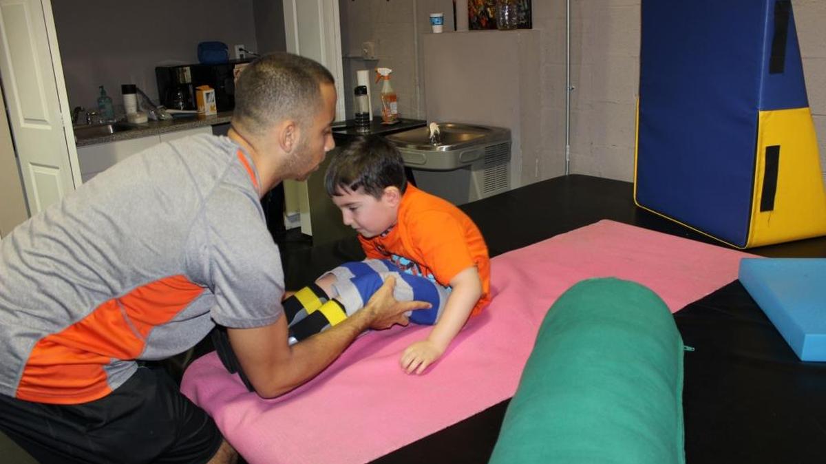 Manny Martínez, de 6 años, recibe dos sesiones de fisioterapia en iAm Able Fitness, en Kendall. Se ejercita bajo la supervisión del terapista Andy Fortuna.