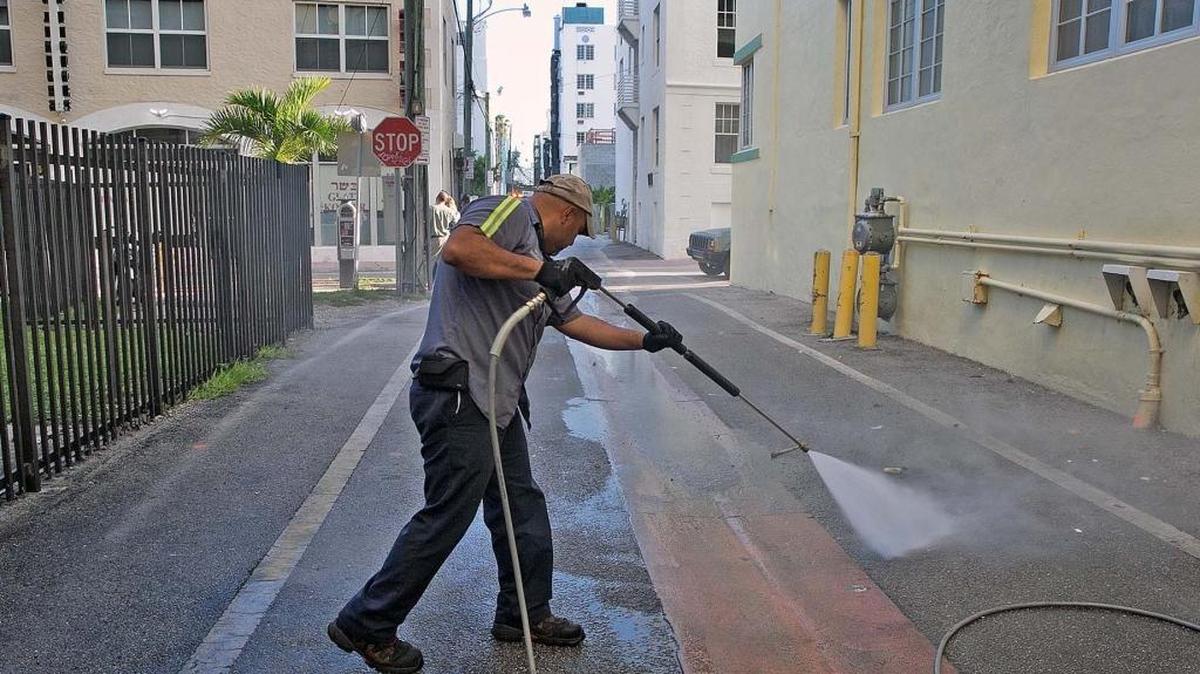 Melvin Gaitan, del Departamento de Aseo de Miami Beach, limpia los callejones con agua caliente a presión para matar larvas.