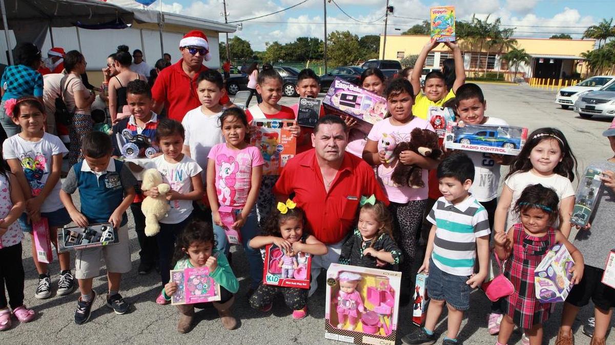 Un grupo de niños rodea a Francisco Portillo (centro), presidente de la Organización Hondureña Francisco Morazán, luego de la entrega de regalos en la iglesia St. Michael the Archangel el sábado.
