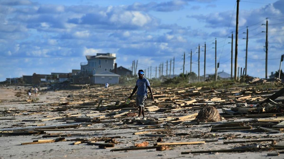 Un hombre camina por una playa de San Agustín cubierta de escombros, el 8 de octubre del 2016, luego del paso del huracán Matthew.