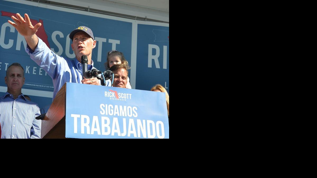 El gobernador de Florida, Rick Scott saluda a partidarios el domingo 2 de noviembre de 2014 durante un mitin en Hialeah, Florida, dos días previo a las elecciones del 4 de noviembre.