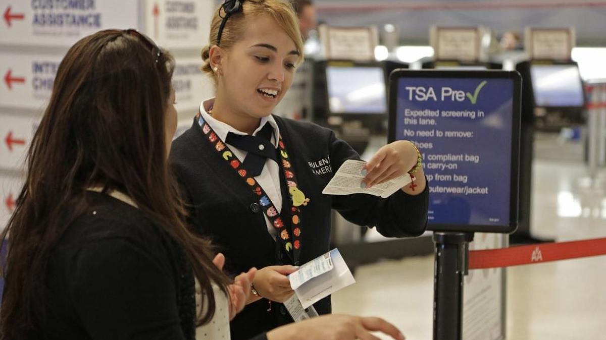 Syndy Pérez (der.) ayuda a una viajera a sortear el prechequeo de TSA en MIA durante el fin de semana de Acción de Gracias.