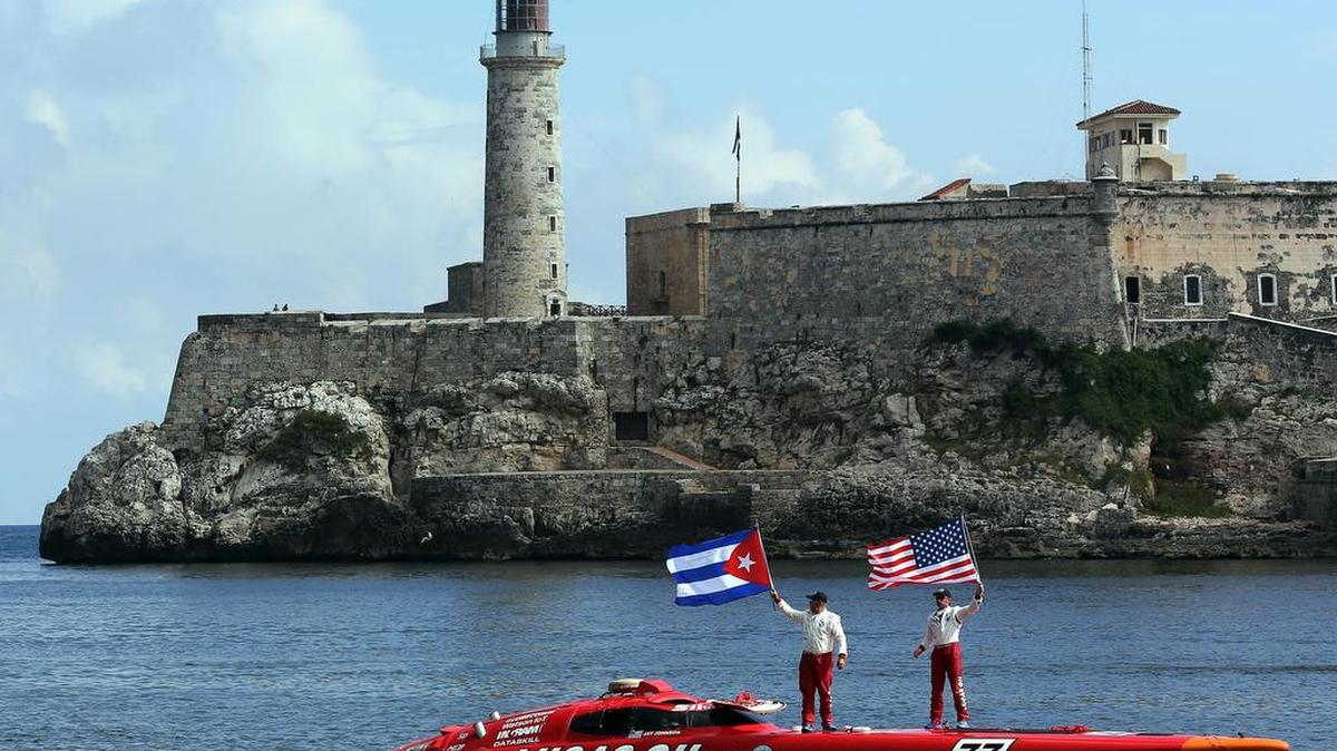 Nigel Hook (d) y Jay Johnson (i), pilotos de la lancha rápida Lucas Oil SilverHook, ondean las banderas de Cuba (i) y EE.UU. (d) durante su arribo el jueves 17 de agosto de 2017, a la bahía de La Habana (Cuba), imponiendo un nuevo récord de velocidad al realizar la travesía Cayo Hueso (Florida) - La Habana en una hora y 18 segundos.