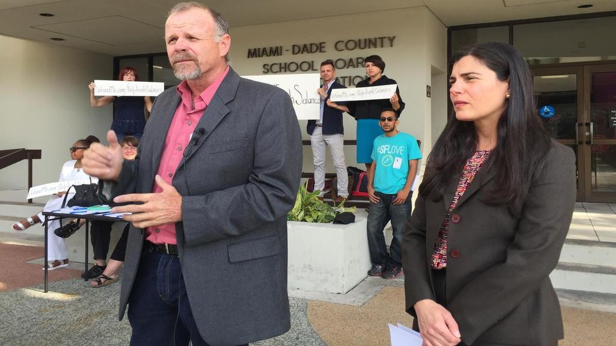 Shawn Beightol y Thais Álvarez se reúnen con otros maestros frente al edificio de la Junta Escolar de Miami-Dade para dar a conocer su intención de presentar una demanda por la falta de pago de bonos por desempeño.