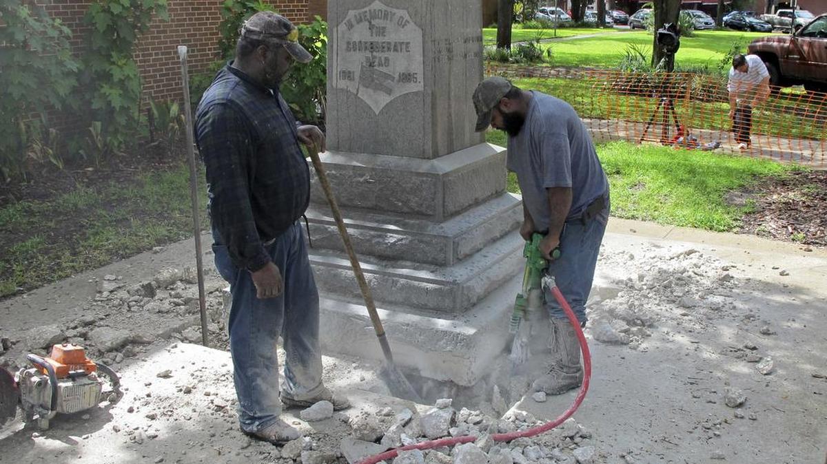 Obreros desmontan el lunes la estatua dedicada al soldado confederado en Gainesville. La estatua será devuelta a la organización Hijas Unidas de la Confederación.