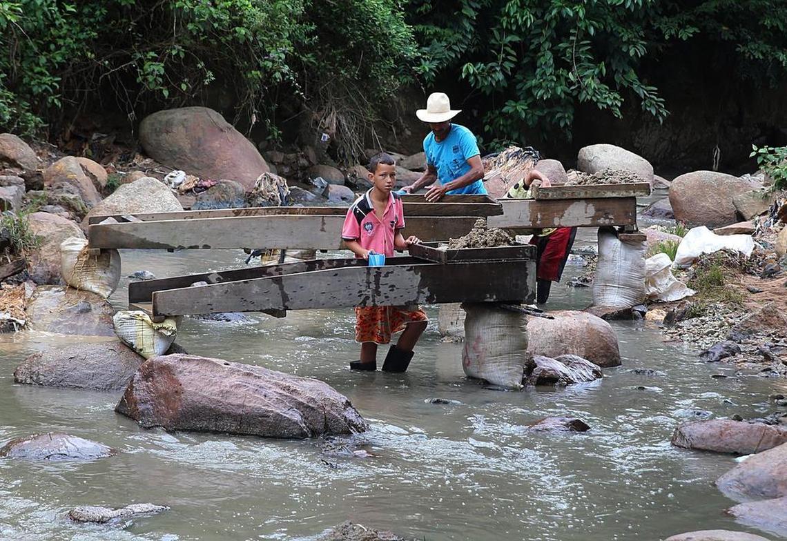Varios trabajadores, incluidos niños, buscan oro en la arena fina que contiene el agua sacada de un río conocido como Cianurada. El agua fue desechada por la planta de procesamiento de Gran Colombia Gold Corp., en el poblado de Segovia, departamento de Antioquia, Colombia.