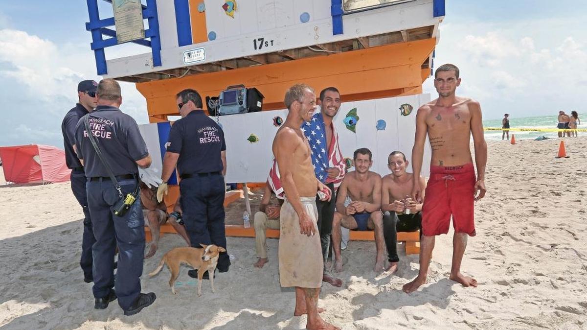 
Los 12 balseros y su perra “Chiquitica”, los cuales llegaron el martes 15 de septiembre a las playas de Miami Beach, descansan a la sombra bajo la casilla del guarda vidas luego de una travesía de seis días en altamar. 


