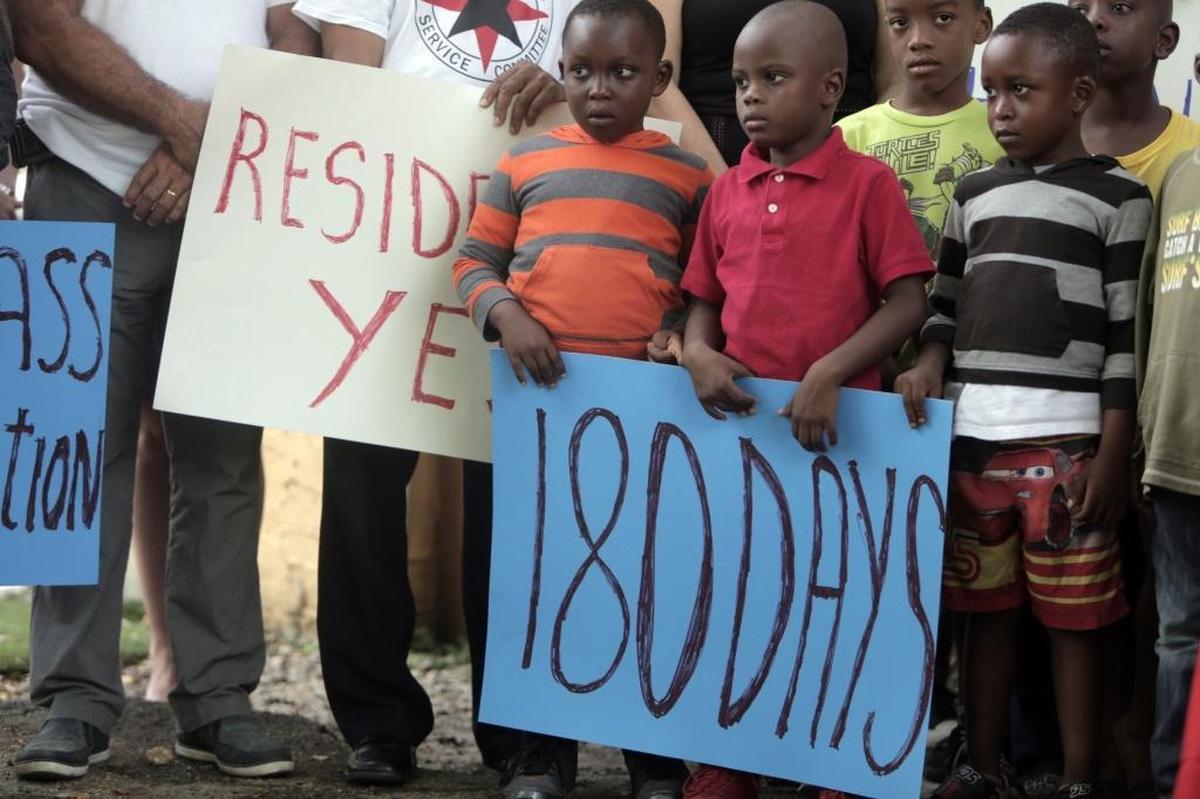 Niños de Miami cuyos padres haitianos enfrentarían la deportación si pierden el TPS, sostienen pancartas el lunes, durante una conferencia de prensa en Miami.